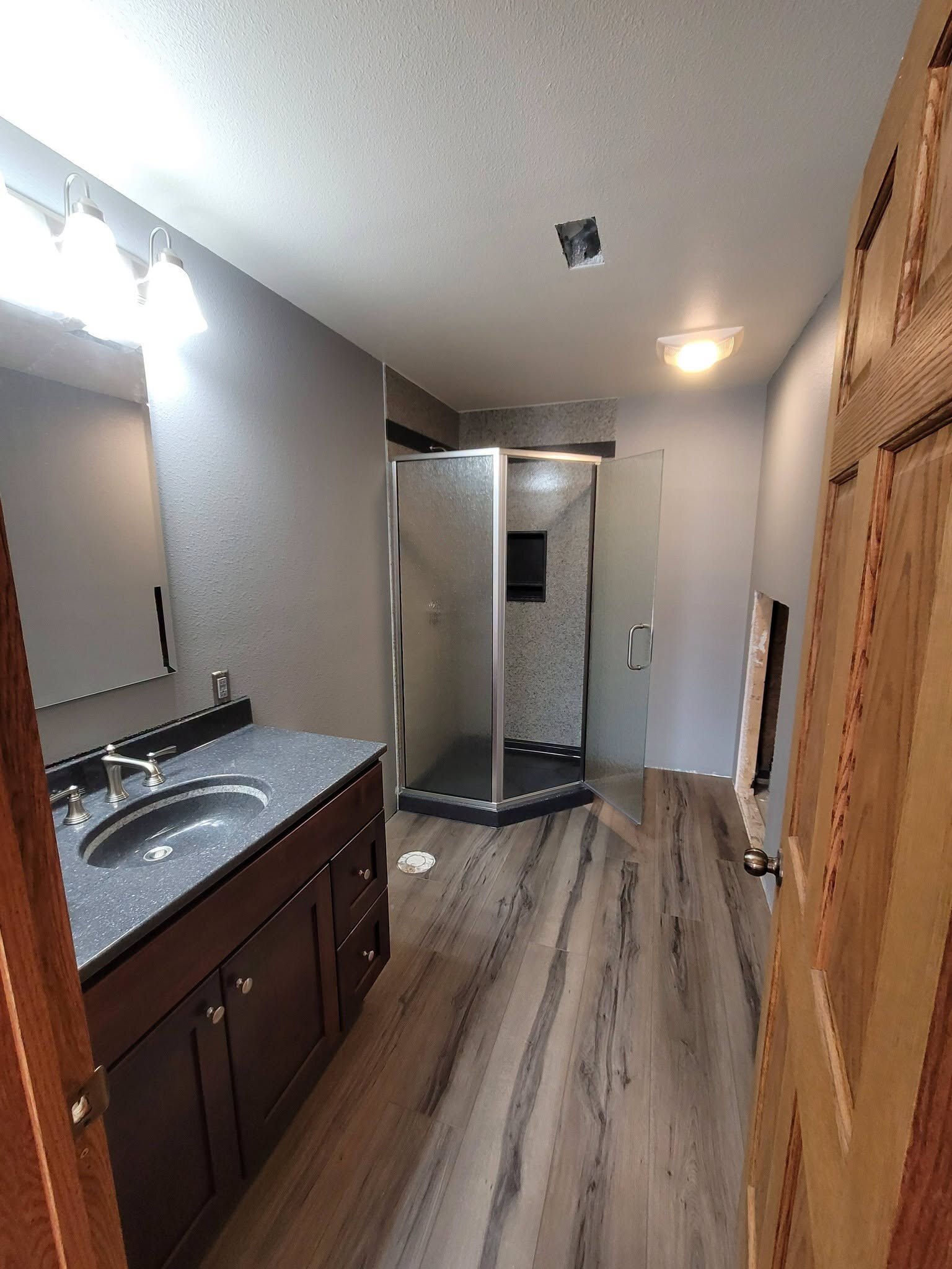 Work in progress with an open ceiling and unfinished openings around the shower and vanity.