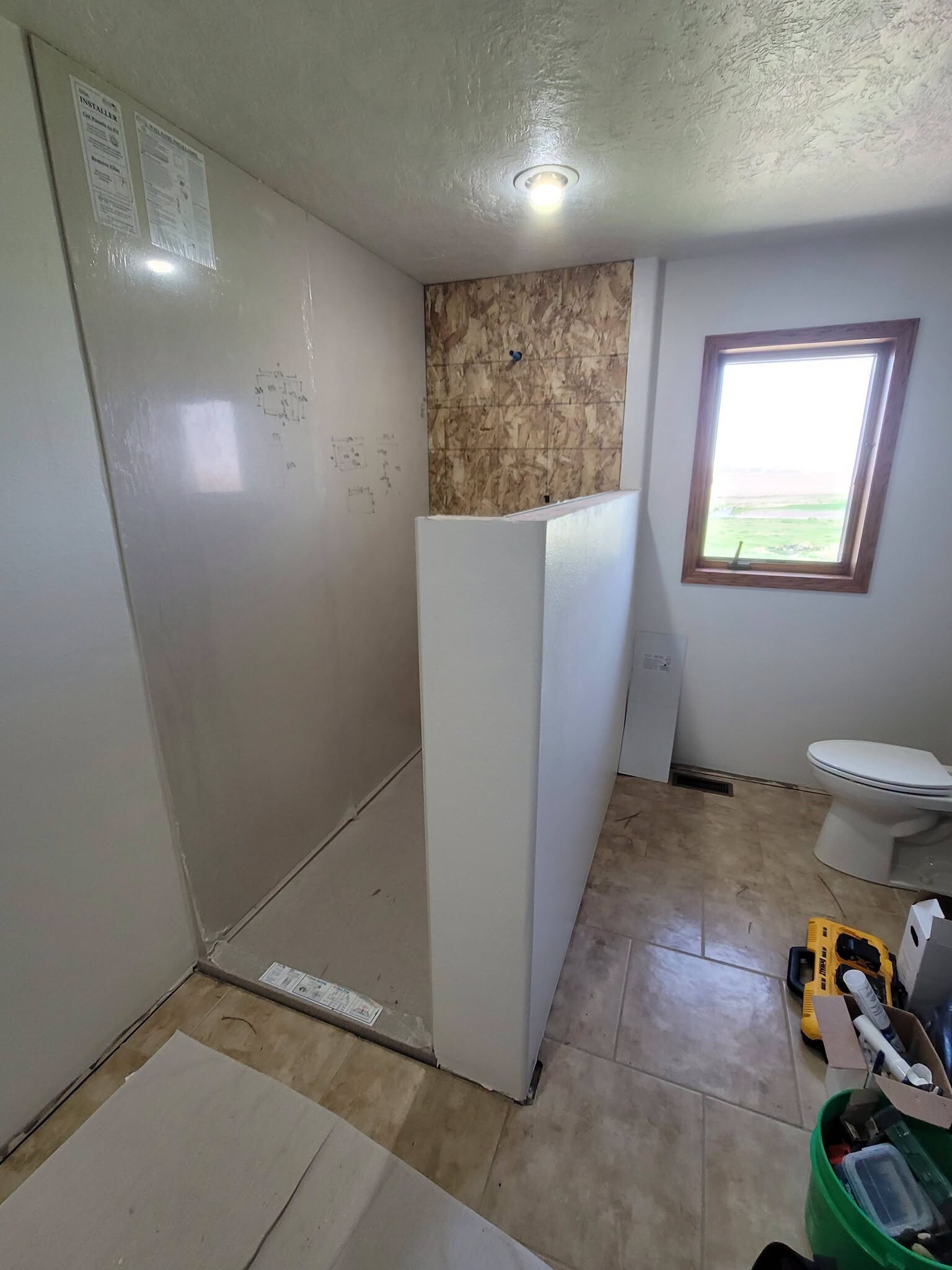 Panels. We installed the custom shower base and wall system, and cut in the recessed storage niches.